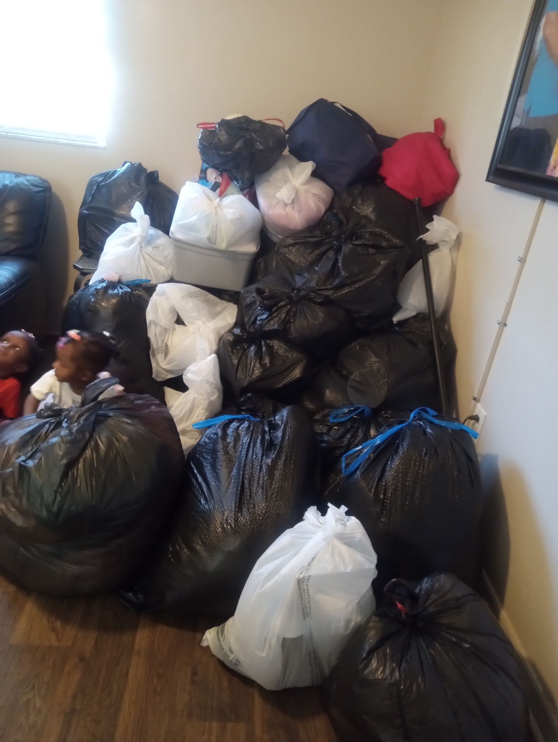 A pile of trash bags sitting on the floor in a living room.